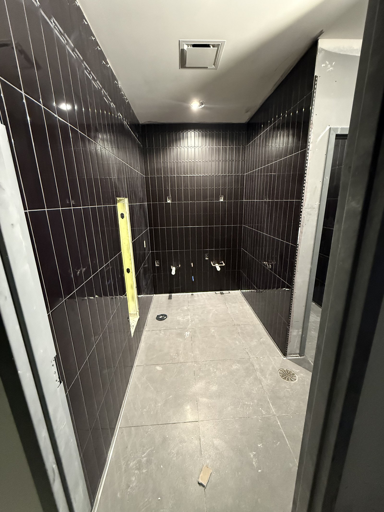 Dark tile installation detail with precision work